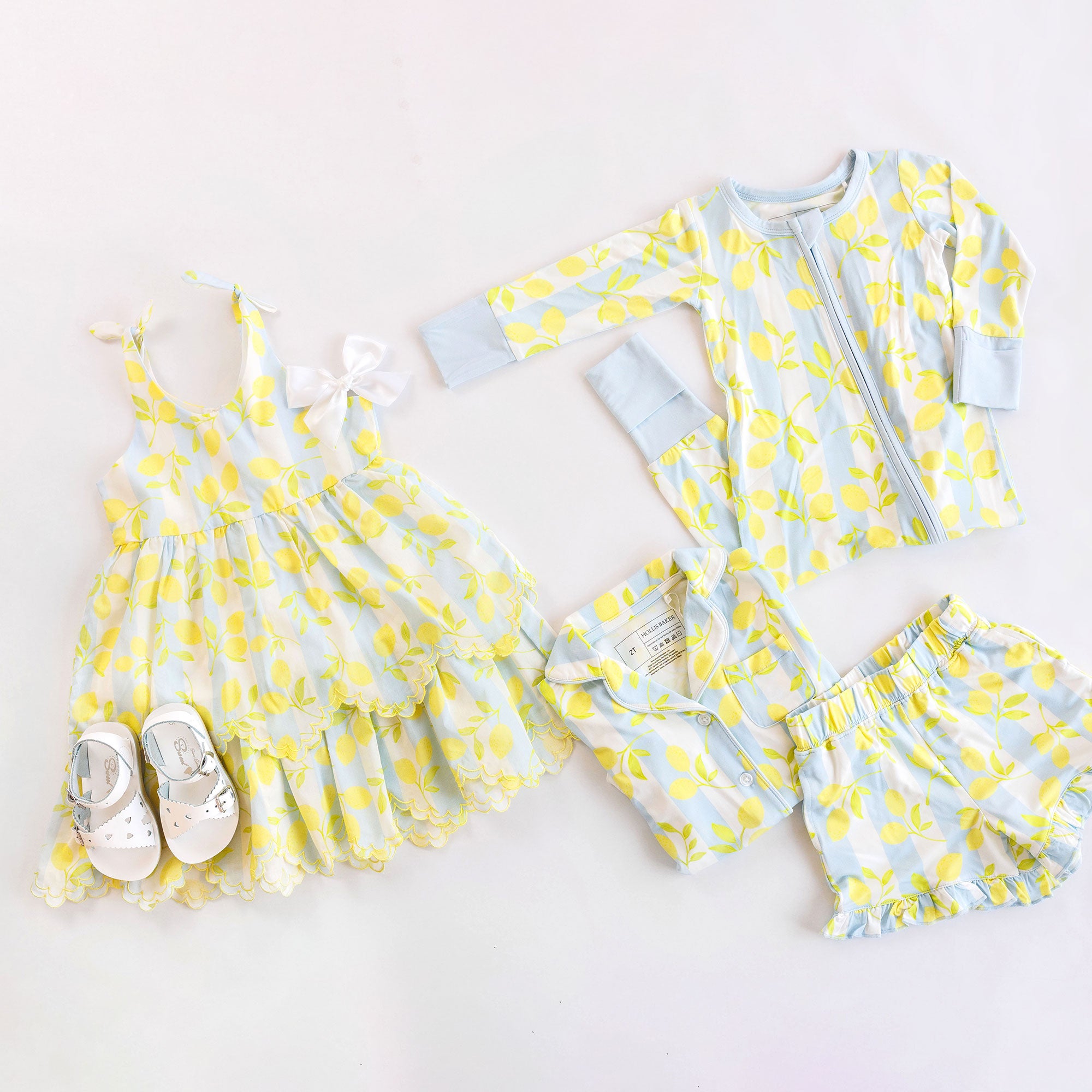 Children's clothing set with yellow and blue lemon pattern on a white background