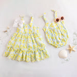 Two children's outfits with yellow lemon patterns on a light background.