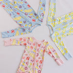 Assortment of several colorful baby zipper rompers on a white background