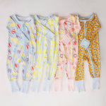 Four children's onesies with different patterns on a light background