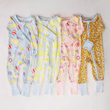 Four children's onesies with different patterns on a light background