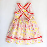 Colorful children's dress with beach-themed pattern on a white background