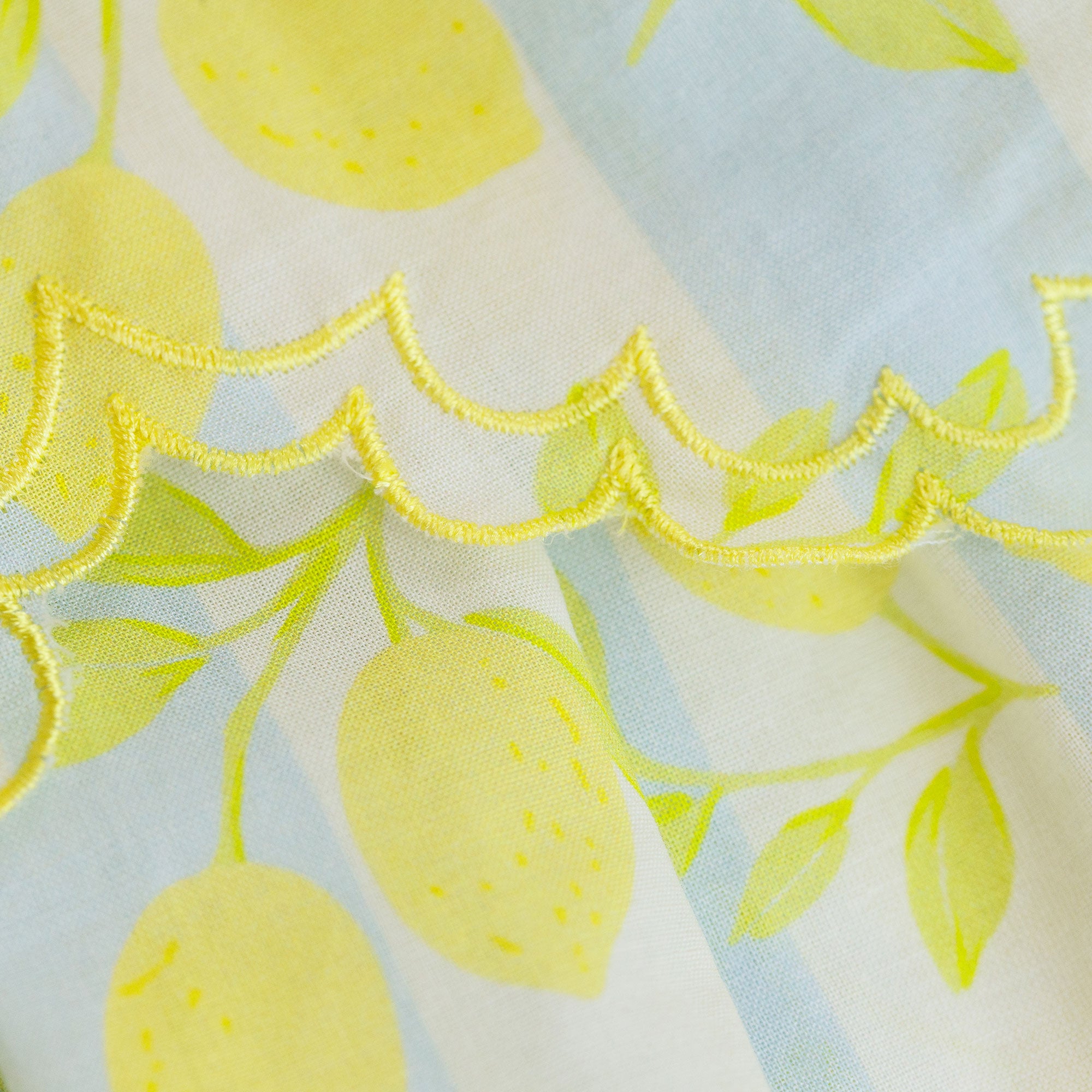 Fabric with yellow lemon pattern on a light blue and white background
