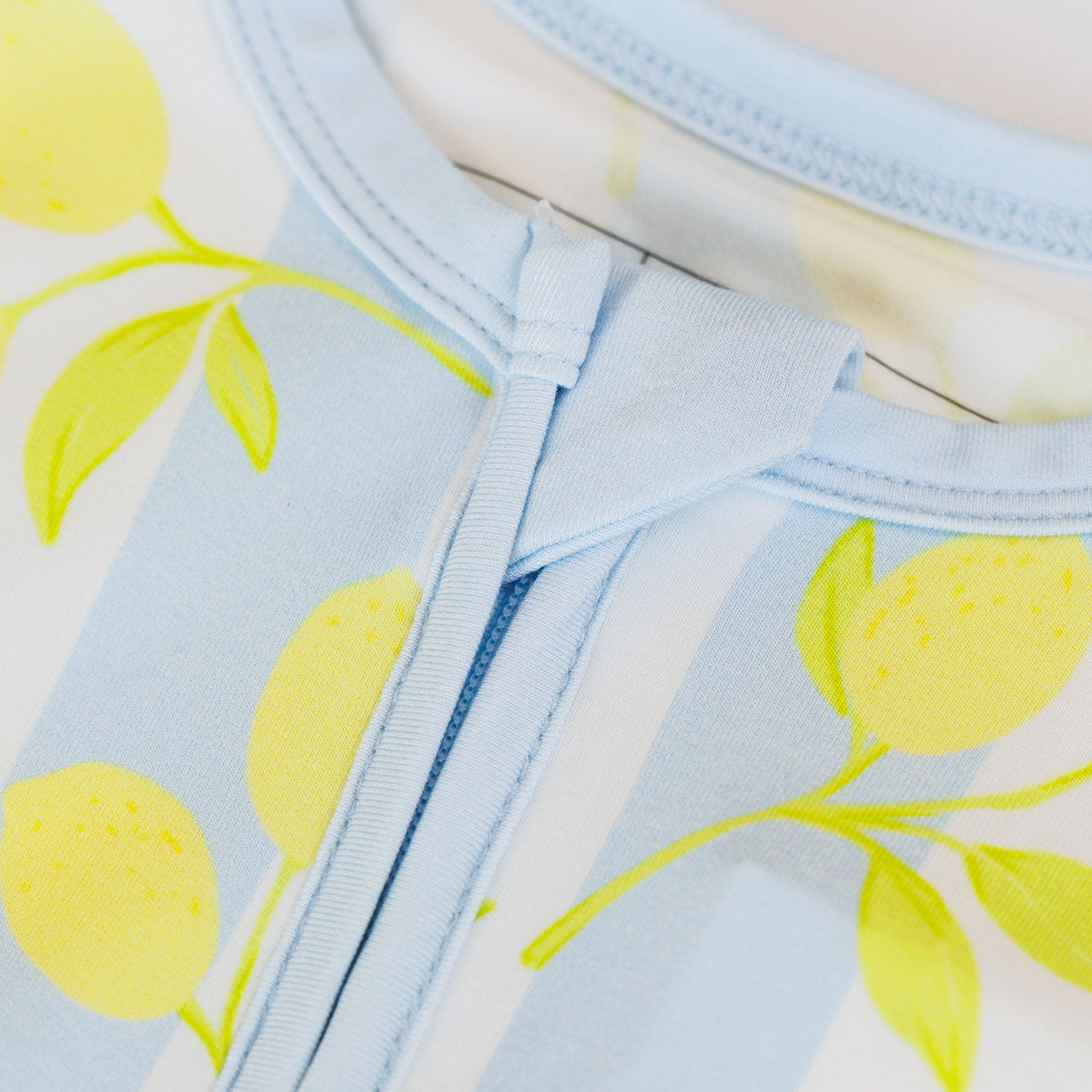 Light blue fabric with yellow lemon pattern on a white background