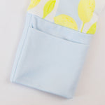 Folded fabric with lemon pattern on top and light blue fabric on the bottom