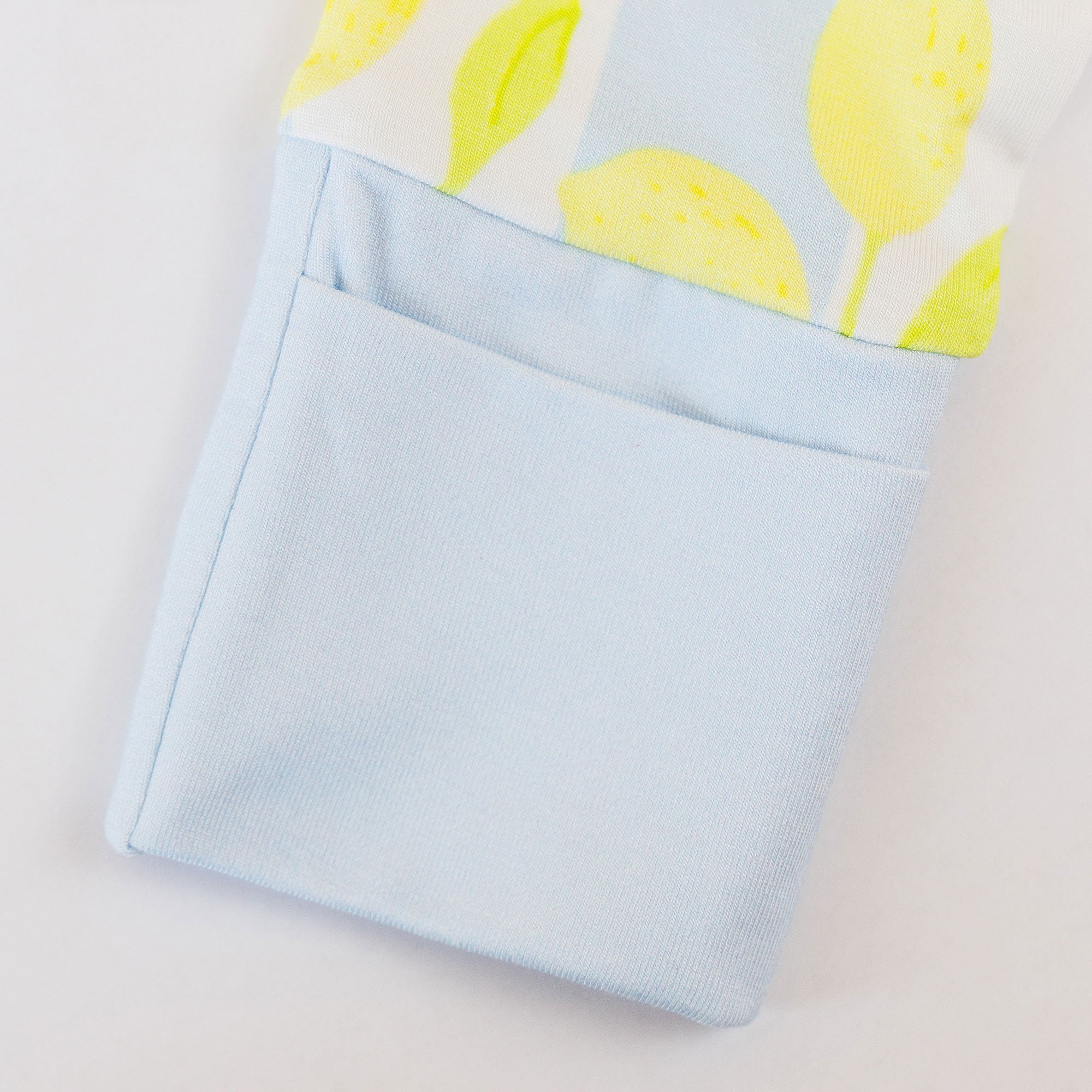 Folded fabric with lemon pattern on top and light blue fabric on the bottom