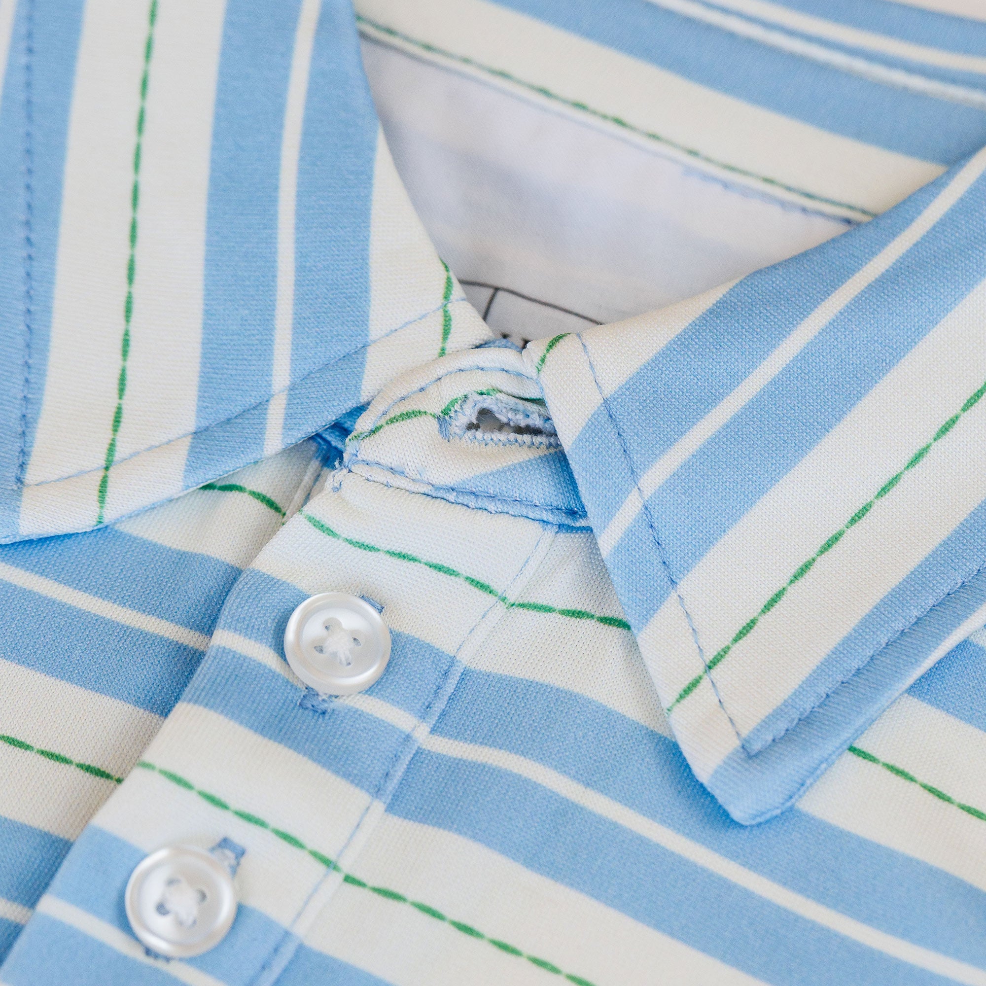 Close-up of a blue and white striped shirt with a button detail.