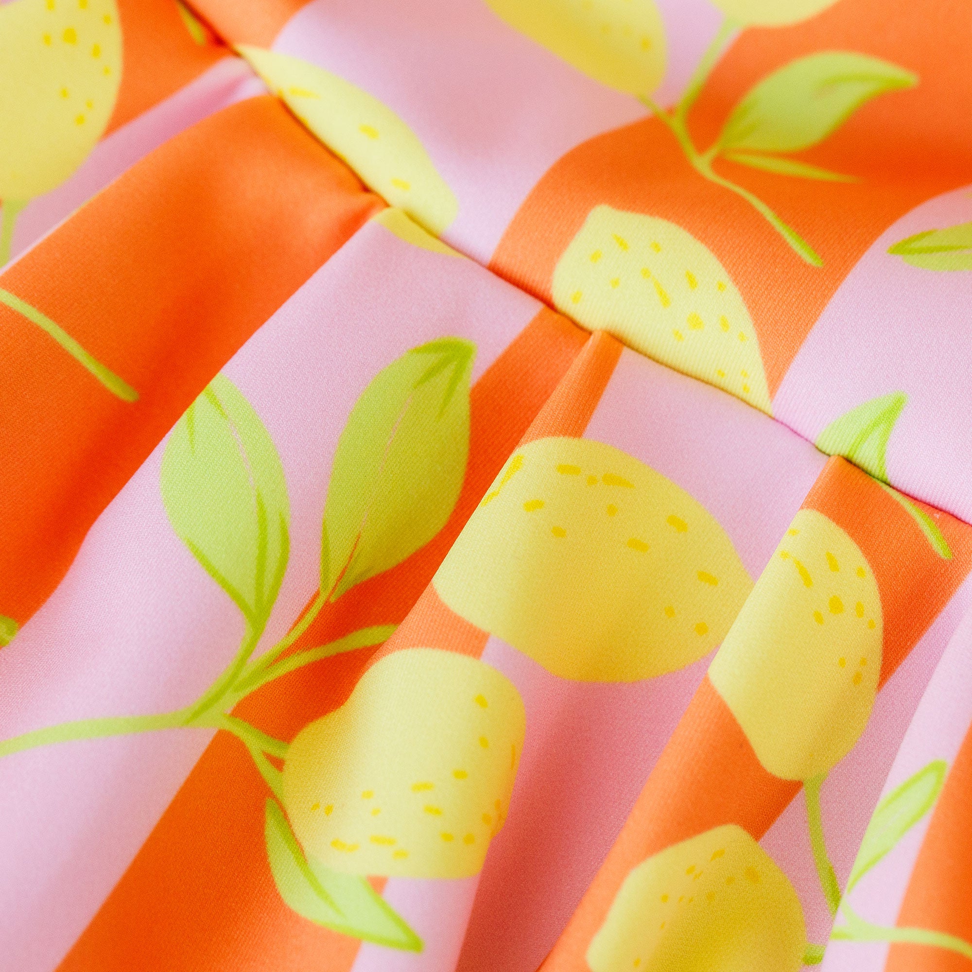 Close-up of fabric with lemon pattern on pink and orange background