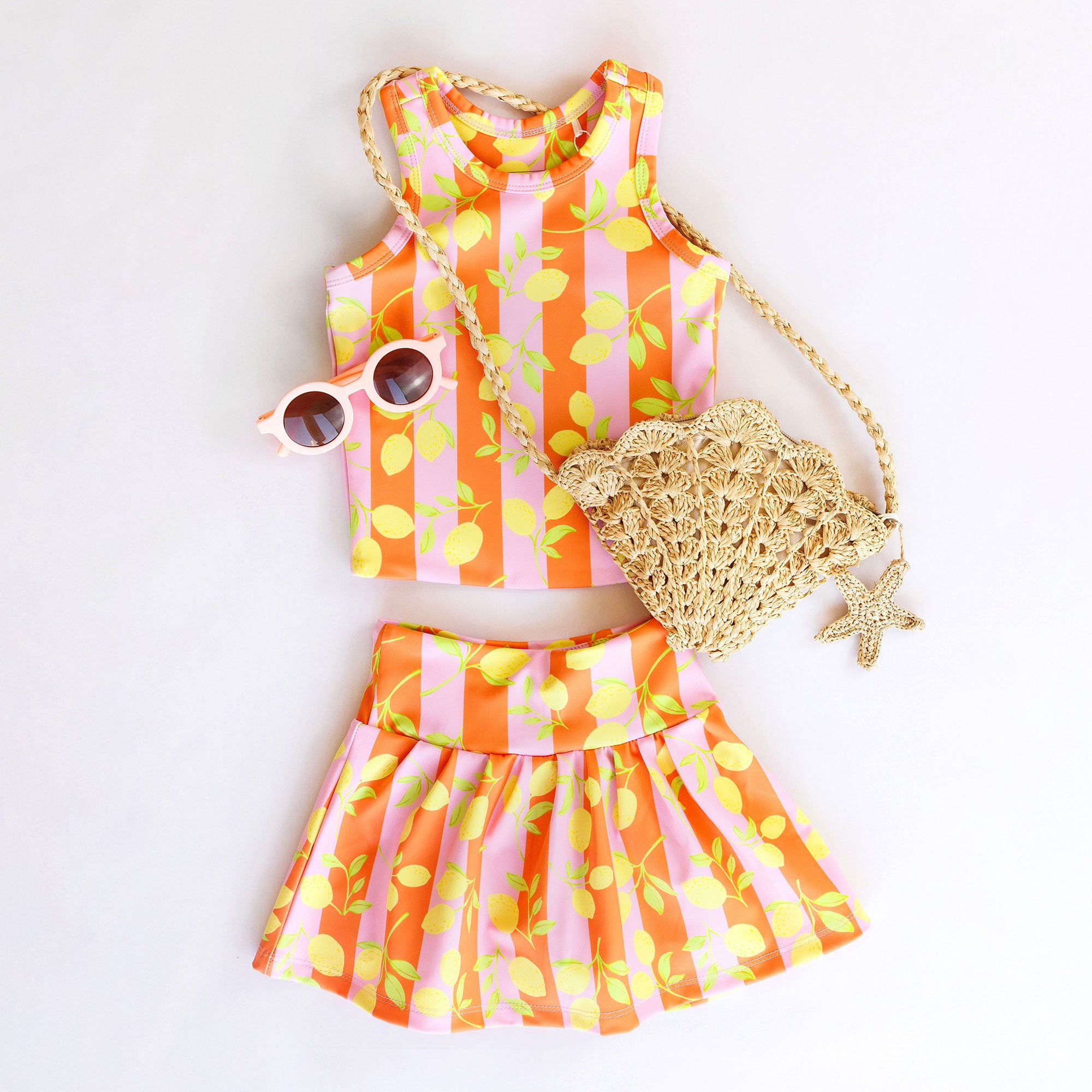 Colorful striped outfit with a skirt, sunglasses, and bag on a white background