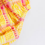 Colorful plaid fabric with yellow and pink patterns on a white background